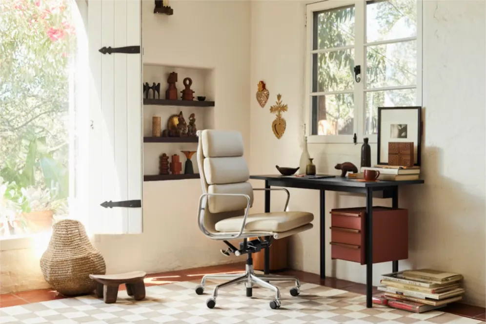 Cream leather Eames chair at a dark wood desk in a bright home office setting